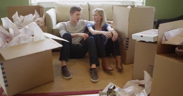 新しい家に荷物を入れてリラックスしたカップル — ストック動画