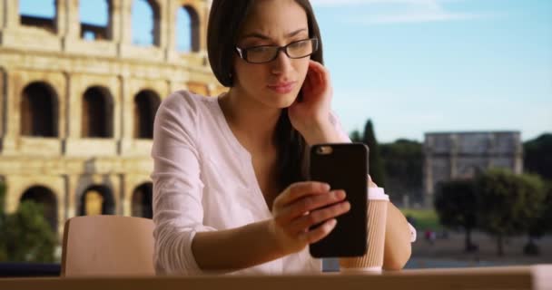 可爱的拉丁女性在罗马竞技场附近检查她的手机是否有遗漏的文字 西班牙裔游客坐在户外 在移动设备上阅读信息 — 图库视频影像