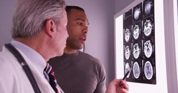 Чоловічий Чорний Пацієнт Дивиться Рентгенівські Промені Мозку Радіологом — стокове відео