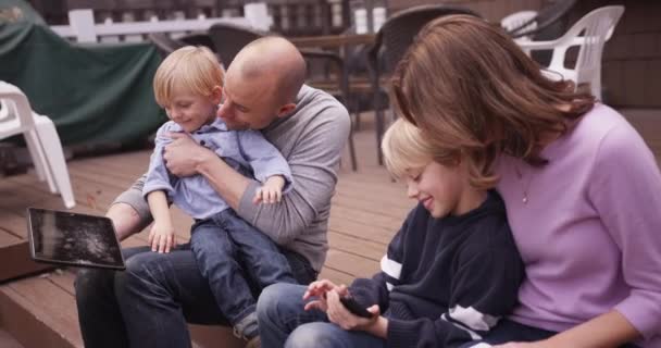 Семейный Портрет Любящих Родителей Делящихся Портативными Устройствами Детьми — стоковое видео