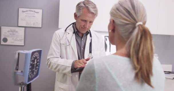 Arzt Mittleren Alters Berät Einen Patienten Mit Tablette — Stockvideo