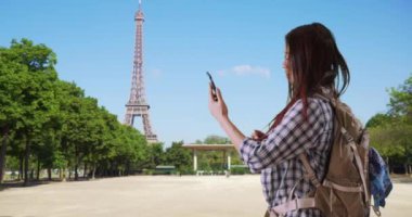 Mutsuz Japon kadın cep telefonu çekmiyor. Akıllı telefonun çalışmasını umarak Eyfel Kulesi 'nin yanında duran bir turist. 4k