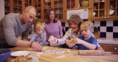 Çekici beyaz aile birlikte taze kurabiyeler yapıyor.
