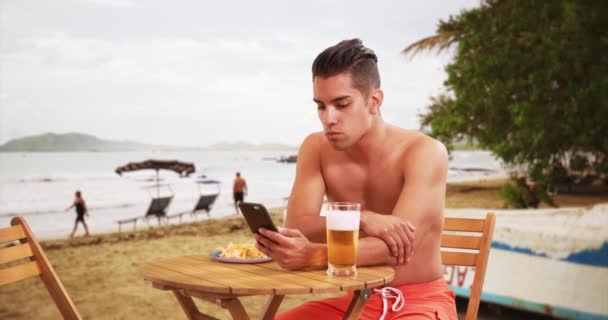Тысячелетний Латиноамериканец Тропическом Отпуске Пьет Пиво Ест Пляже Латиноамериканский Турист — стоковое видео