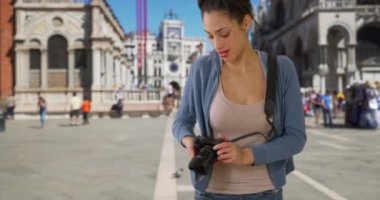 Güzel Latin kadın St. Mark meydanında fotoğraf çekiyor. Venedik 'i gezerken gülümseyen sevimli turist gördüğü bir şeyin fotoğrafını çekiyor. 4k