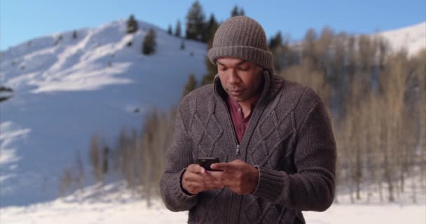 Афроамериканец Дрожит Ледяной Тундре Своем Смартфоне Черный Парень Позирует Снегу — стоковое видео