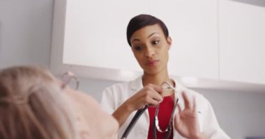 Güzel bayan doktor, hastanın hayati organlarını steteskopla kontrol ediyor.