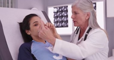 Güzel bir spor kızı bir doktorla beyin sarsıntısını kontrol ediyor.