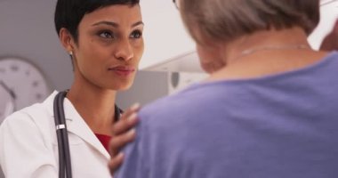 Genç Afrikalı doktor olgun bir hastayla iletişim kuruyor.