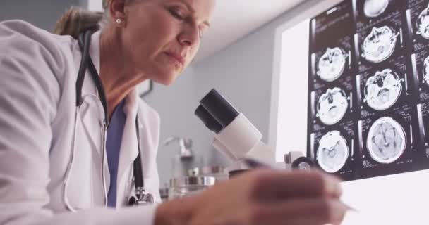 Radiologin Mittleren Alters Schaut Durchs Mikroskop — Stockvideo