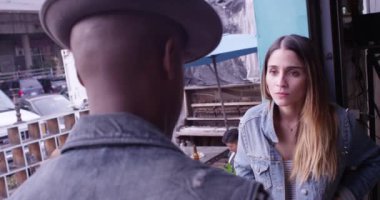 Seksi, çekici İspanyol bir kadının arka planda parti veren bir arkadaşıyla konuşması.