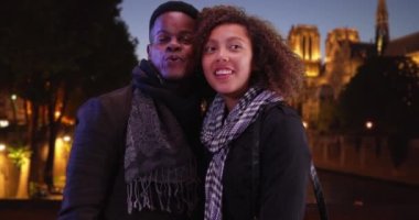 Geceleri Paris 'i gezen mutlu siyahi çift. Balayı standındaki turist çift Seine 'de etrafa bakınıp işaret ediyorlar. 4k