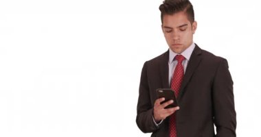 İş adamı mesajlaşır veya sosyal medyayı beyaz arka planlı cep telefonuyla kullanır. İspanyol milenyum adamı takım elbiseli ve arka planda fotokopi alanı ve akıllı telefonla sıkı bir kravat takıyor. 4k