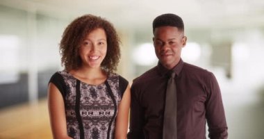 İş ekibi çağdaş bir ofiste bir portre için poz veriyor. Afrika kökenli Amerikalı erkek ve kadın modern ofiste duruyor. İki siyah milenyum çalışanı birlikte poz veriyor. 4k.