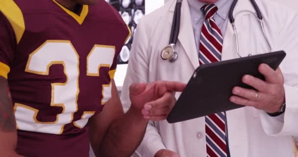 Close Médico Olhando Para Computador Tablet Com Atleta Esportivo — Vídeo de Stock