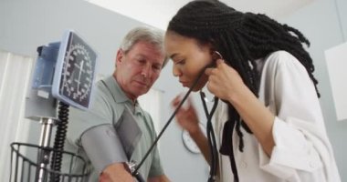 Afrikalı kadın Doktor hastanın kan basıncı kontrol