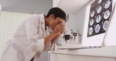 Genç akıllı kadın doktor içinde mikroskop arıyorsunuz