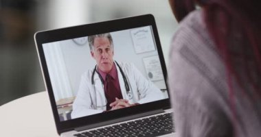 Kadın dizüstü bilgisayarında kıdemli doktorla konuşuyor.