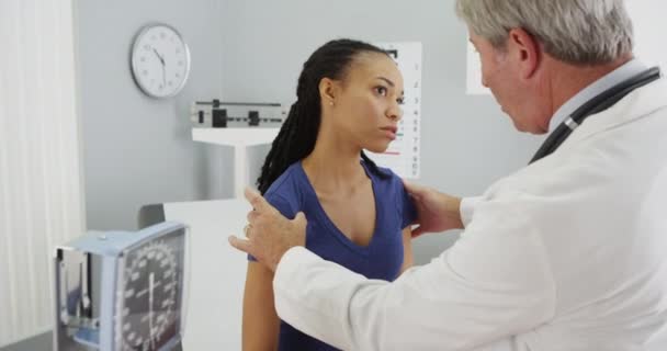 黒人女性の肩をチェックシニア医師 — ストック動画