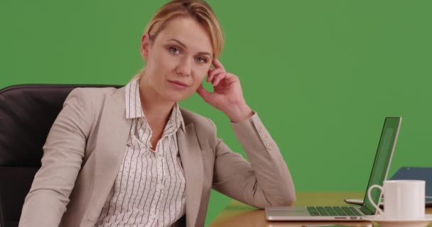 緑色の画面でカメラを見て机に座っているビジネスマンの女性 緑の画面でキーまたは構成されます — ストック動画