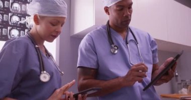 Akıllı telefon ve tablet kullanan iki doktor.