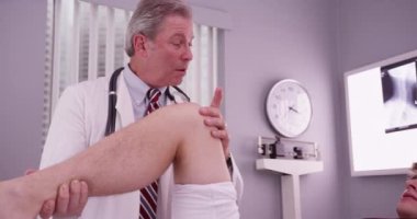 Orta yaşlı doktor diz yaralanması incelenmesi ile üniversite spor atlet