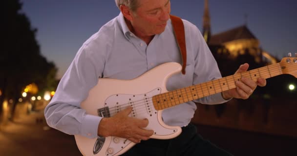 年长的白人男性吉他手在人行道上弹奏他的电吉他 成熟的白人音乐家在公众面前大吵大闹 — 图库视频影像