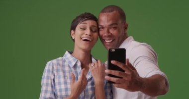 Siyah bir çift yeşil ekranda nişanlarını kutlamak için selfie çekiyor. Anahtar ya da birleşik olmak üzere yeşil ekranda.
