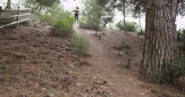 Parkta tepeden aşağı koşan sağlıklı bir Asyalı kadın.