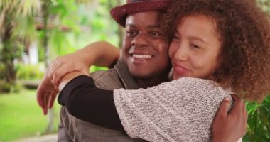 Genç siyahi erkek ve kadın tropikal bir tatildeyken birbirlerine sarılıyorlar. Milenyum Afrikalı Amerikalı çift tatilde sarılıyor. 4k.