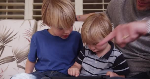 一个可爱的白人小男孩和家人一起玩平板电脑 — 图库视频影像