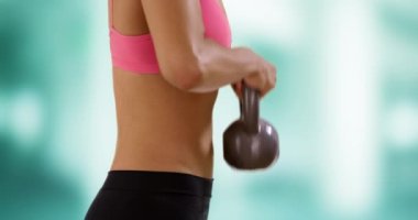 Kettlebell ağırlığını kaldıran genç siyahi kadının yakın çekimi. Üst vücut egzersizi yapan siyah kadın portresi.