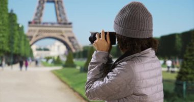 Mutlu çekici siyah kadın Eyfel Kulesi 'nin fotoğrafını çekiyor. Şirin bin yıllık dişi, günün maceralarını fotoğraflayarak Paris 'i keşfediyor. 4k