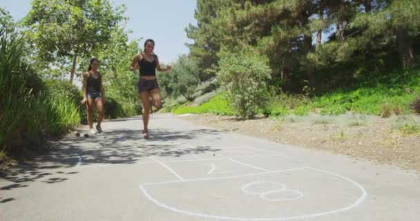 Jovens Mulheres Jogando Hop Scotch Parque — Vídeo de Stock