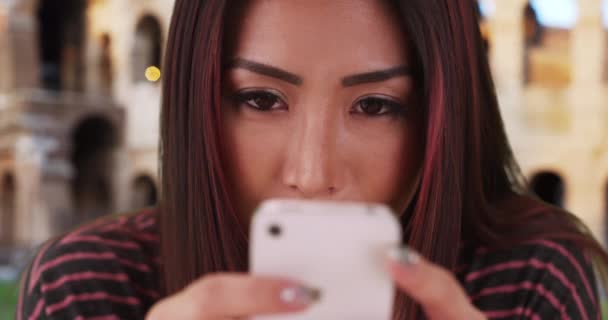 在Colosseum附近 一群漂亮的日本女人正在用智能手机发短信 在罗马度假时 迷人的女人笑着用手机给朋友留言 — 图库视频影像