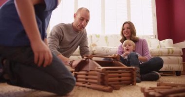 Oturma odasında güzel bir aile oynuyor.