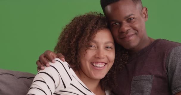 笑着的快乐的黑人夫妇在他们的沙发上的绿色屏幕上摆出肖像的姿势 在绿色屏幕上键入或合成 — 图库视频影像