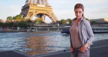 Fransa, Paris 'i gezen sıradan bir genç kadın Eyfel Kulesi' nin yakınlarına bakmak için duruyor. Milenyum Kafkas güzelliği Paris atmosferinin tadını çıkarıyor. 4k
