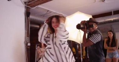 Stüdyoda moda çekimlerinde dönen ve zıplayan İspanyol kadın model.