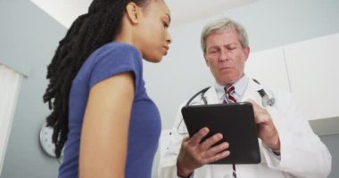 Kıdemli doktor Afrikalı kadınların tıbbi geçmişlerine bakıyor.