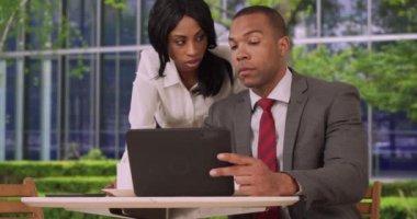 Bir çift hevesli iş adamı dışarıdaki bir tabletten borsayı kontrol ediyor. İki Afro-Amerikalı iş ortağı bir ped cihazında işle ilgili bilgilere bakıyor. 4k