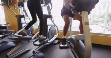 Spor aletleriyle spor yaparken konuşan sağlıklı siyah ve İspanyol çift.