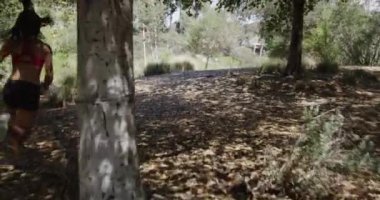 Aktif genç Asyalı kadın parkta koşu yapıyor.