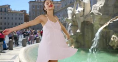Roma 'daki fıskiyenin yanında dönen kaygısız Latin kadın. Güzel, mutlu turist beyaz elbisesiyle mutlu bir şekilde dönüyor. 4k