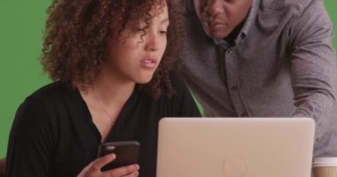 Yeşil ekranda çalışan iki siyah iş adamı. Anahtar ya da birleşik olmak üzere yeşil ekranda.