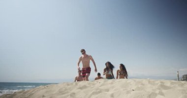 Otantik genç grup Interracial arkadaşıyla beach kıyıdan yürüyüş