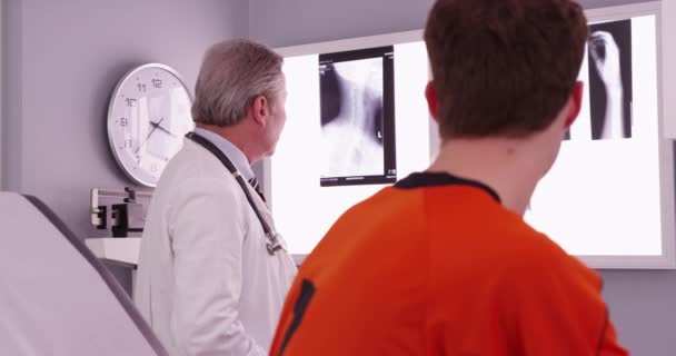 Médico Revisando Las Radiografías Lesiones Del Cuello Atleta Deportivo — Vídeo de stock