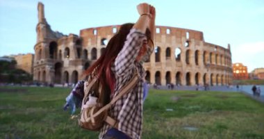 Japon kadın Kolezyum 'u göreceği için heyecanlı. İtalya 'da sırtüstü atlayıp gülümseyen sevimli Asyalı kadın. 4k