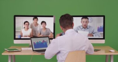 İş adamı, yeşil ekranda çeşitli profesyonel avukatlarla uluslararası video konferansı yapmak için gece geç saatlere kadar çalışıyor. Anahtar ya da birleşik olmak üzere yeşil ekranda.