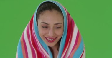 Latin bir kadın yeşil ekrana sarılmış bir havluyla rahatlıyor. Anahtar ya da birleşik olmak üzere yeşil ekranda.